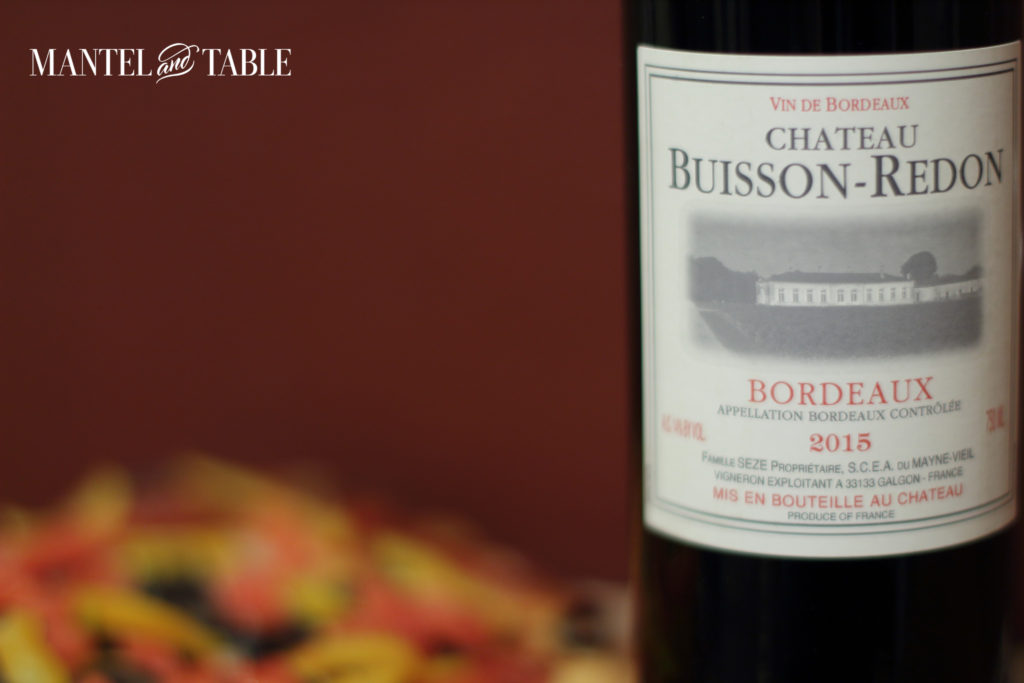 Bottle of Chateau Buisson-Redon next to a delicious looking pizza.