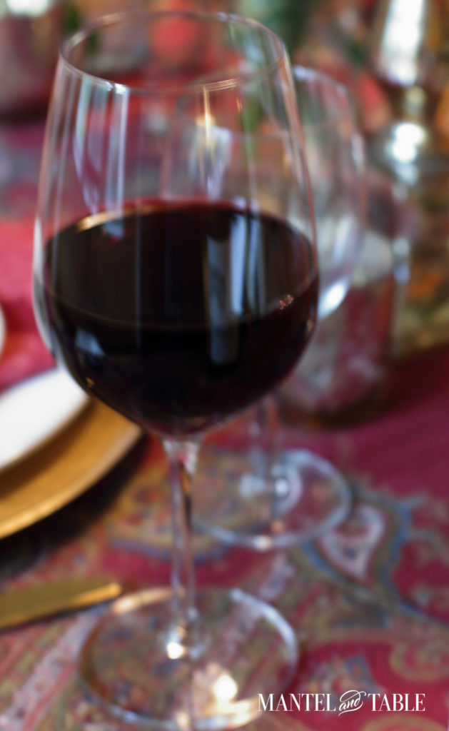Glass of Chateau Paret pizza wine on a red patterned tablecloth