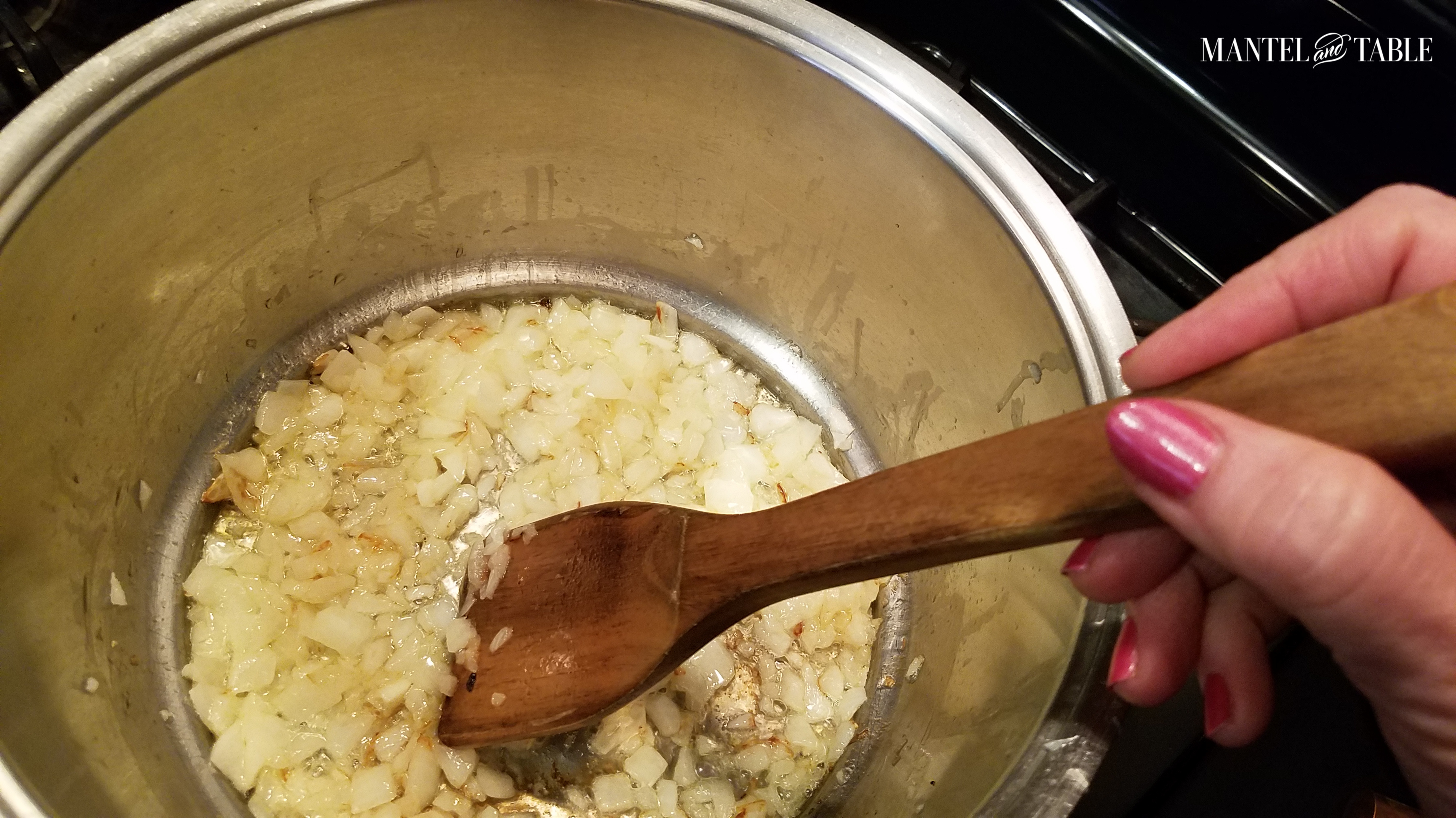 Onions sauteing in a big silver pot.