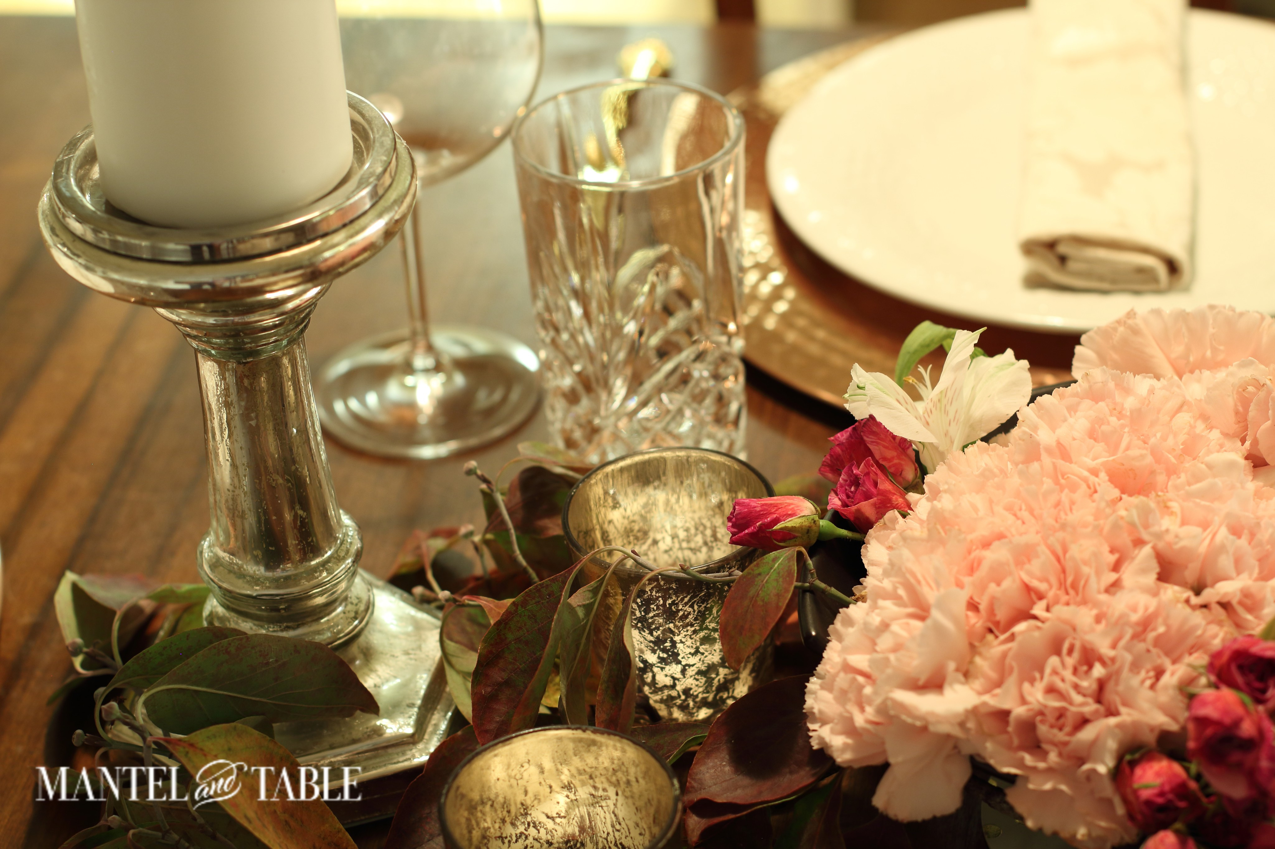 Copper chargers, white plates, pink flowers, and candles