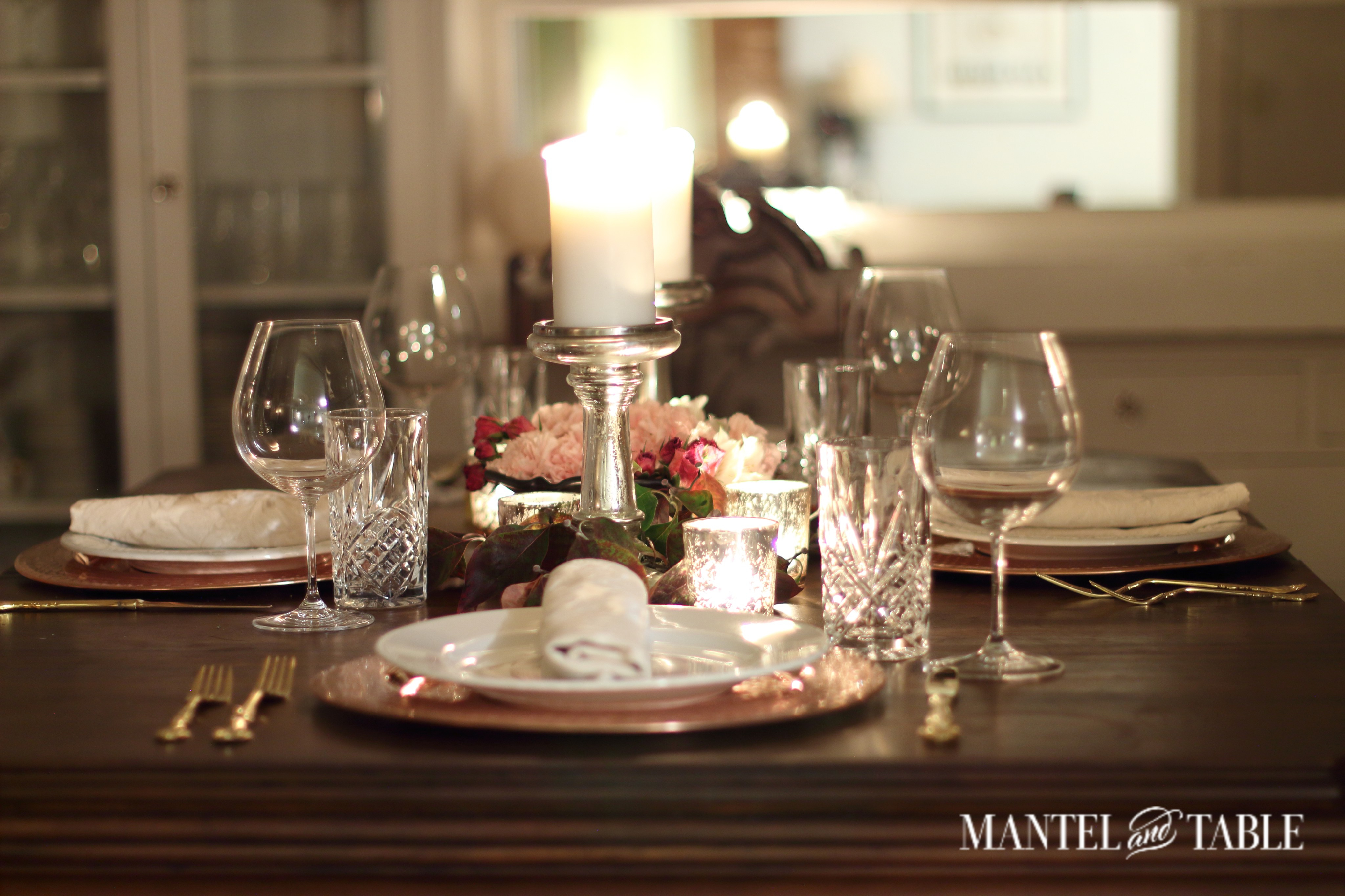 Dark wood table, copper charges, white plates & blush napkins.