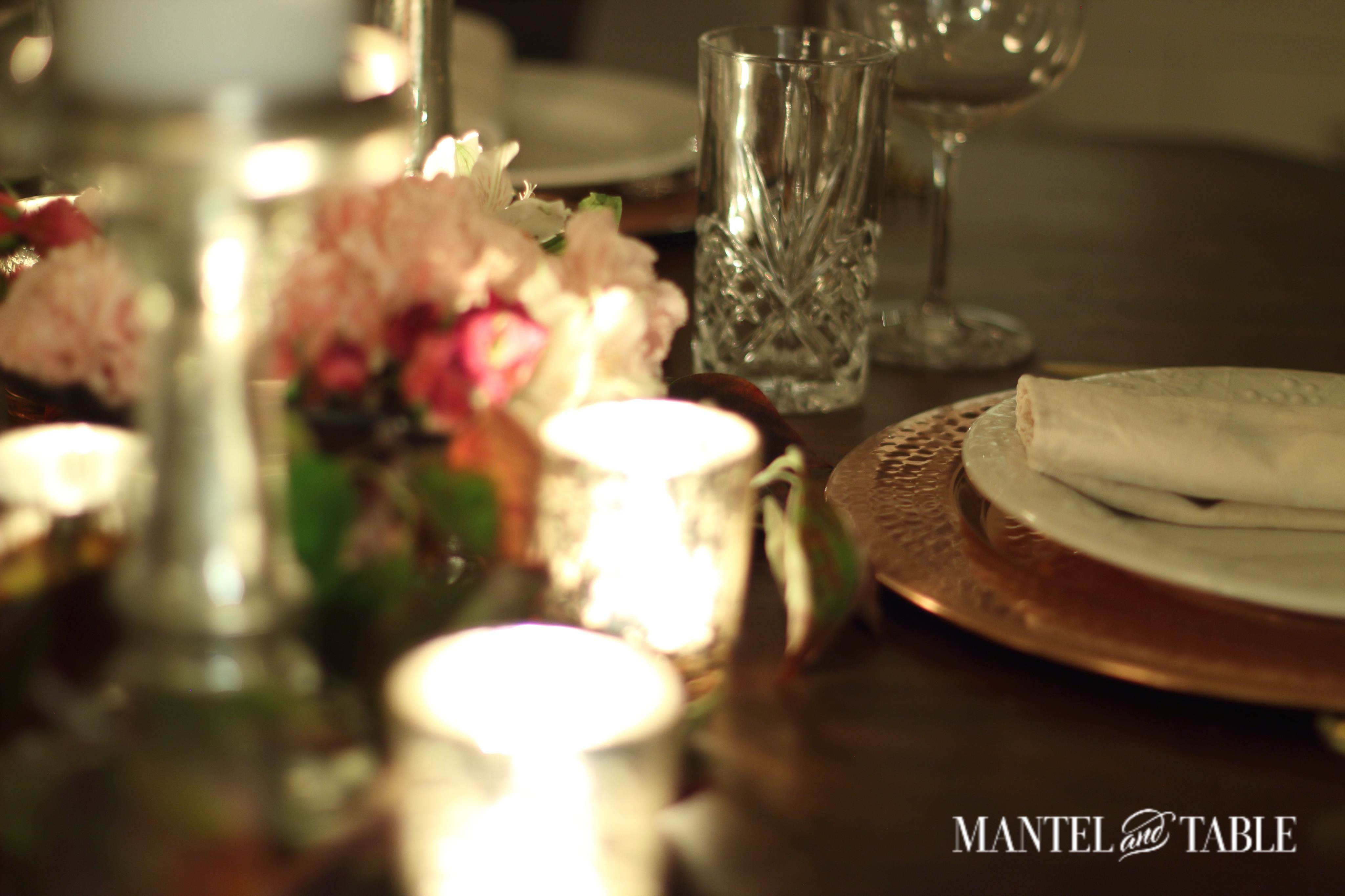 Copper charger, white plates, and candlelight