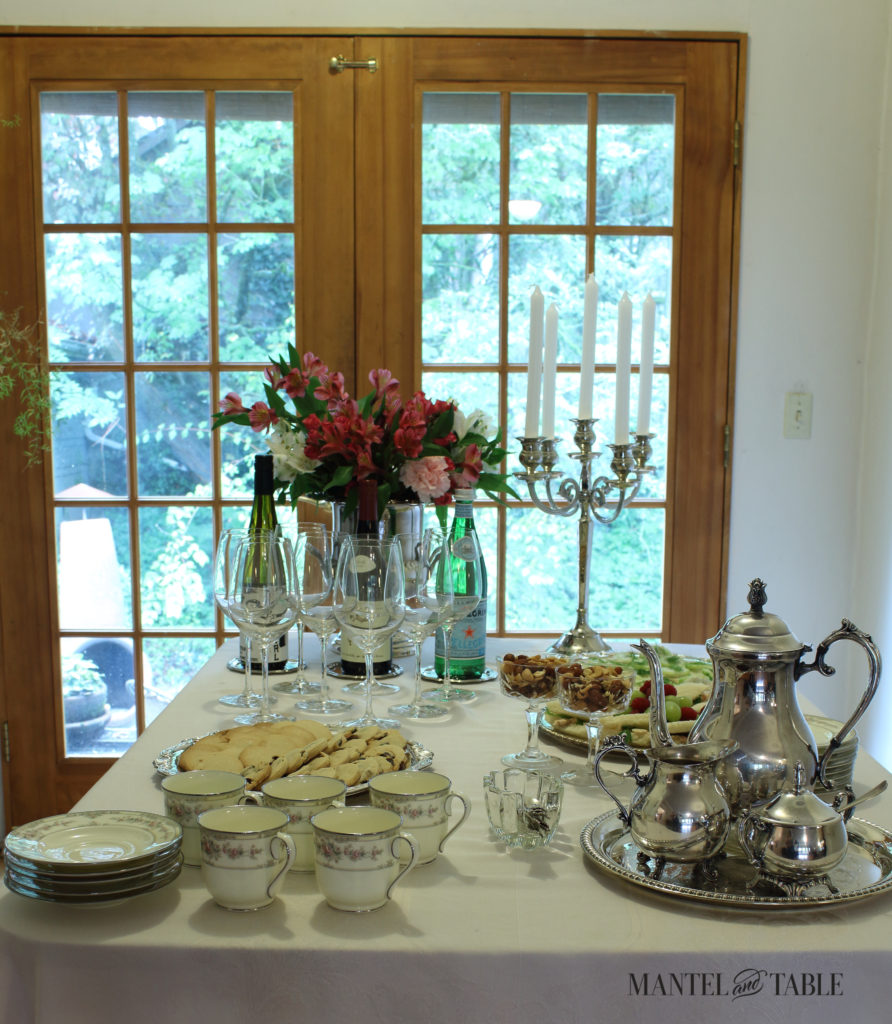 Tea table with pink flowers, silver candelabra, & silver tea service