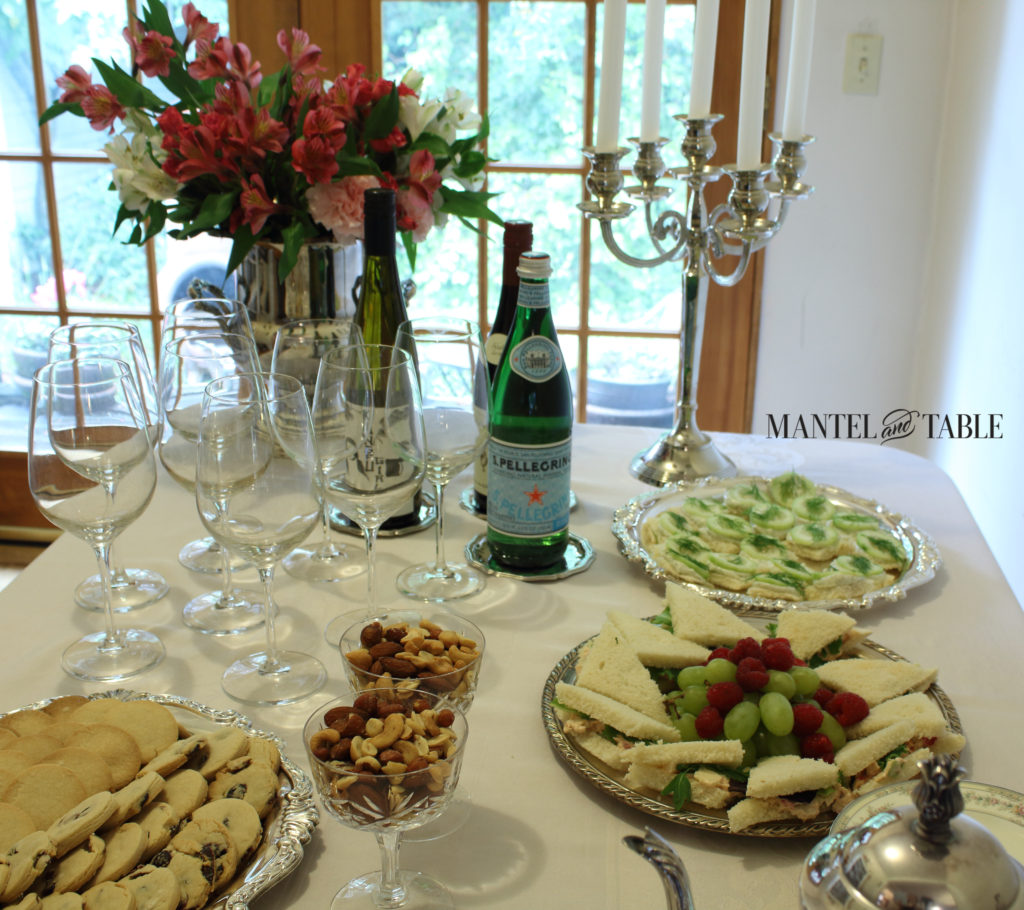 Tea table with food on silver platters.