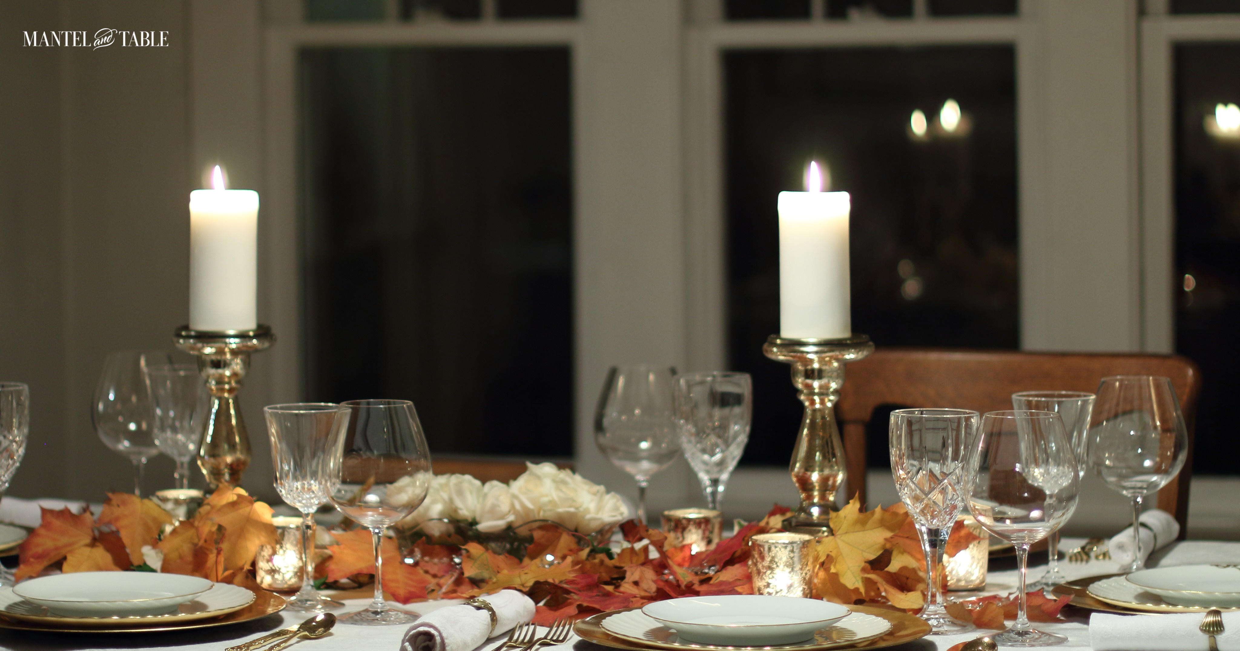 White & gold tablesetting with fall leaves & mercury glass pillar candles