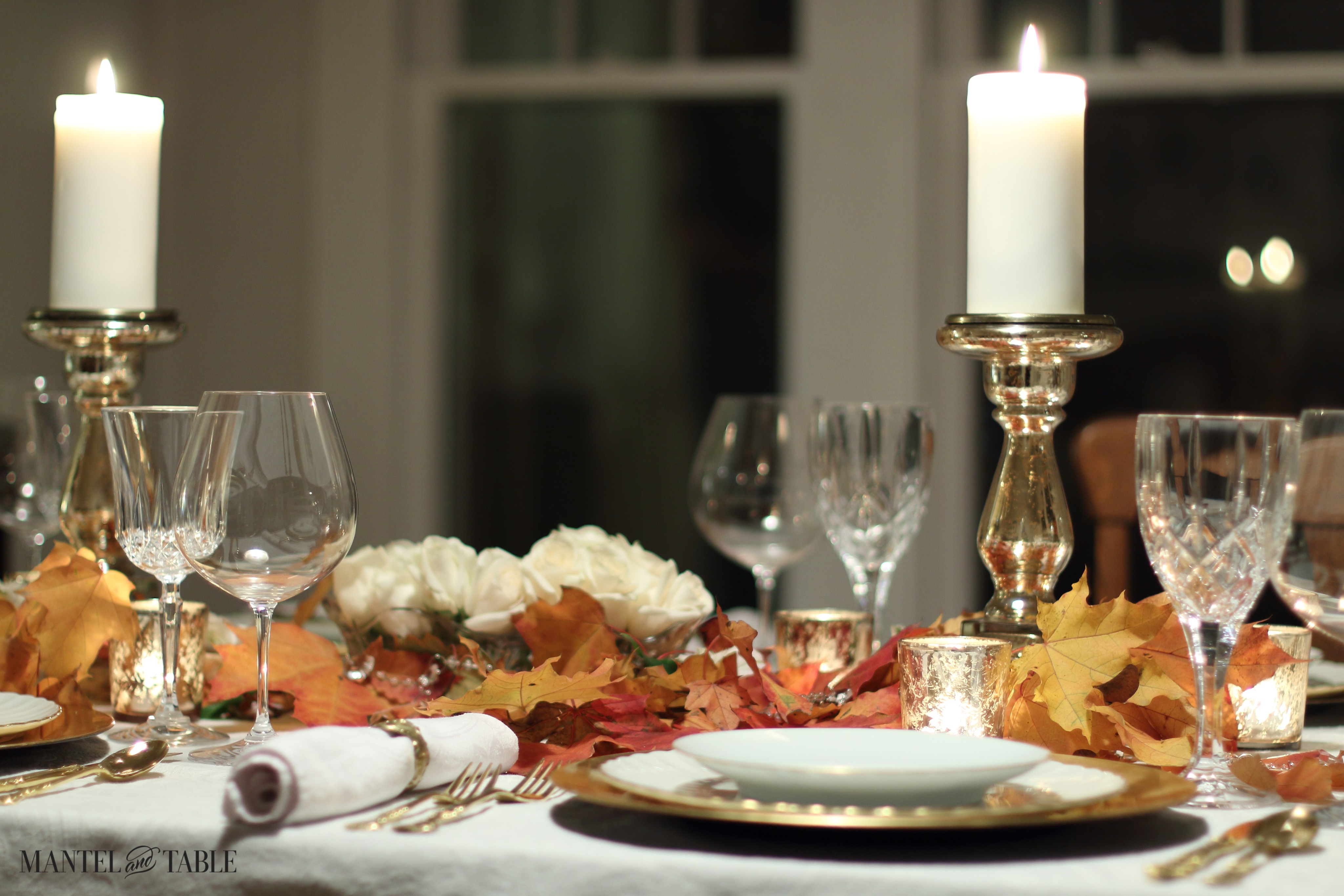 White & gold table with red & yellow fall leaves & white roses centerpiece