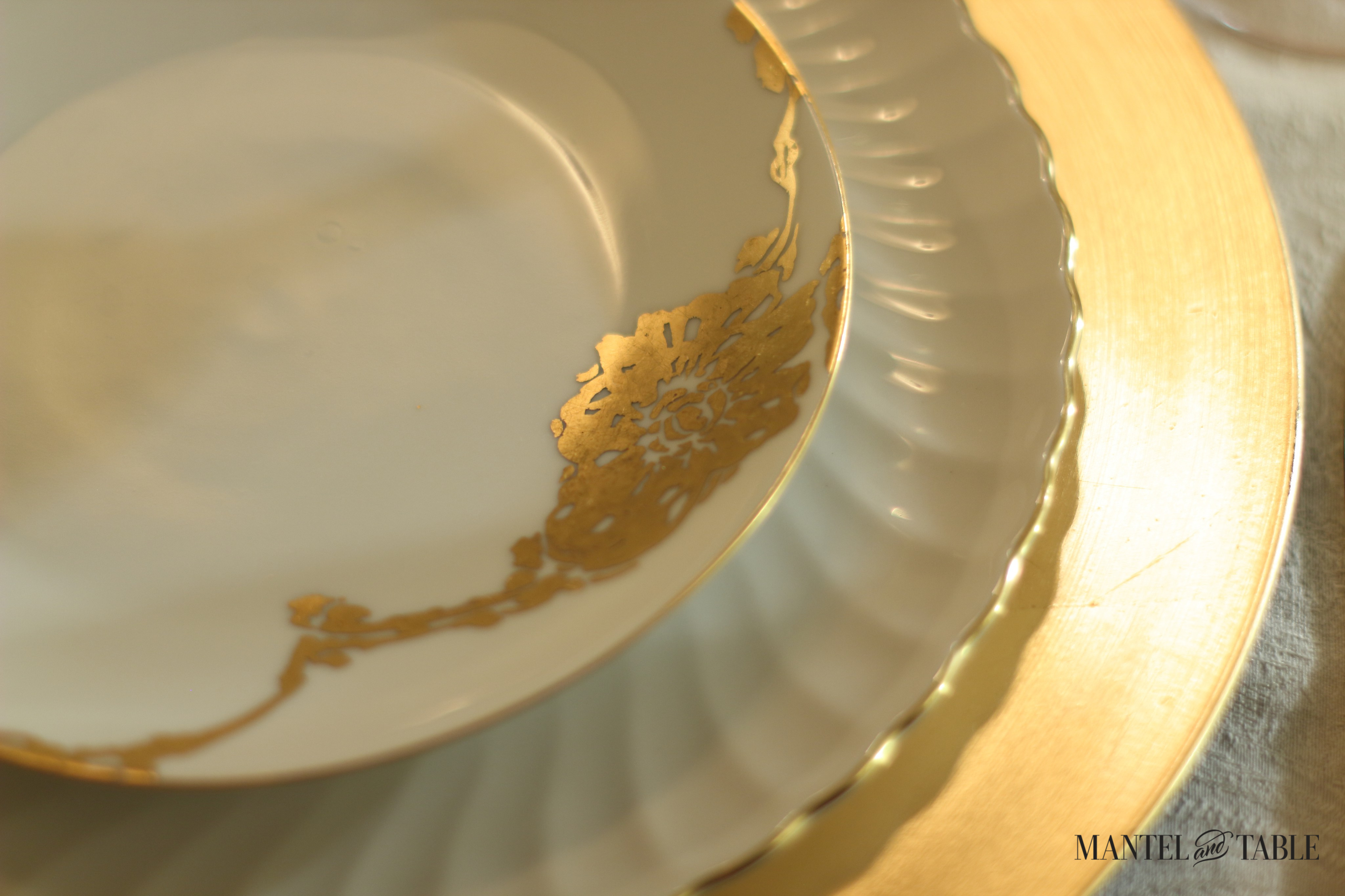 Plate stack. Gold charger, white scalloped dinner plate with gold trim, white china salad plate with handpainted gold leaf flower design