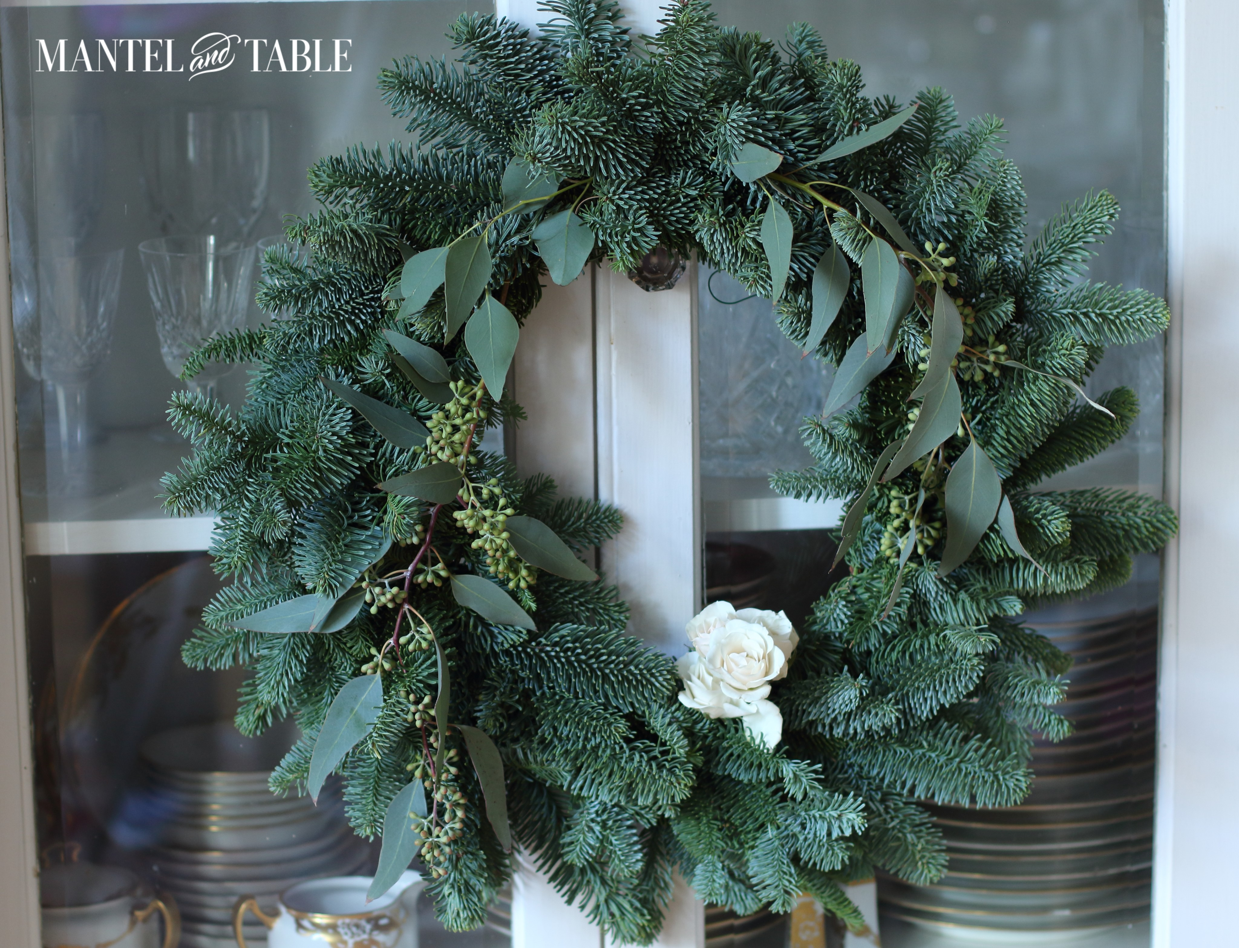 Evergreen wreath with white roses
