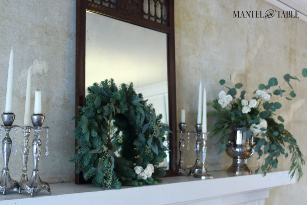 White mantel w/evergreen wreath
