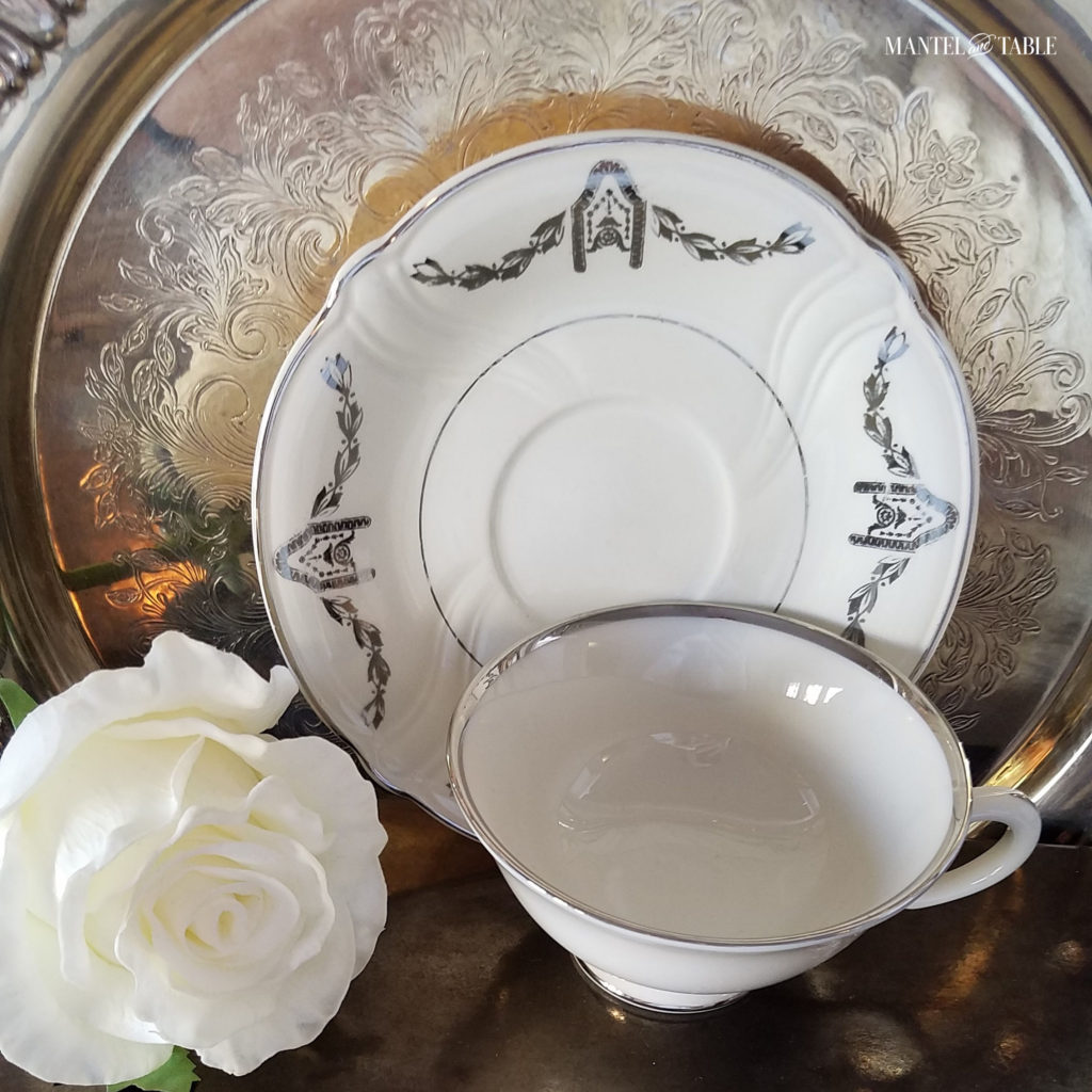 white & silver teacup with svintage silver tray and white rose.