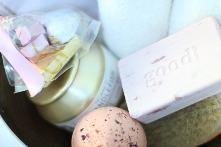 White towels, pink soap & bath ball in a gold bowl