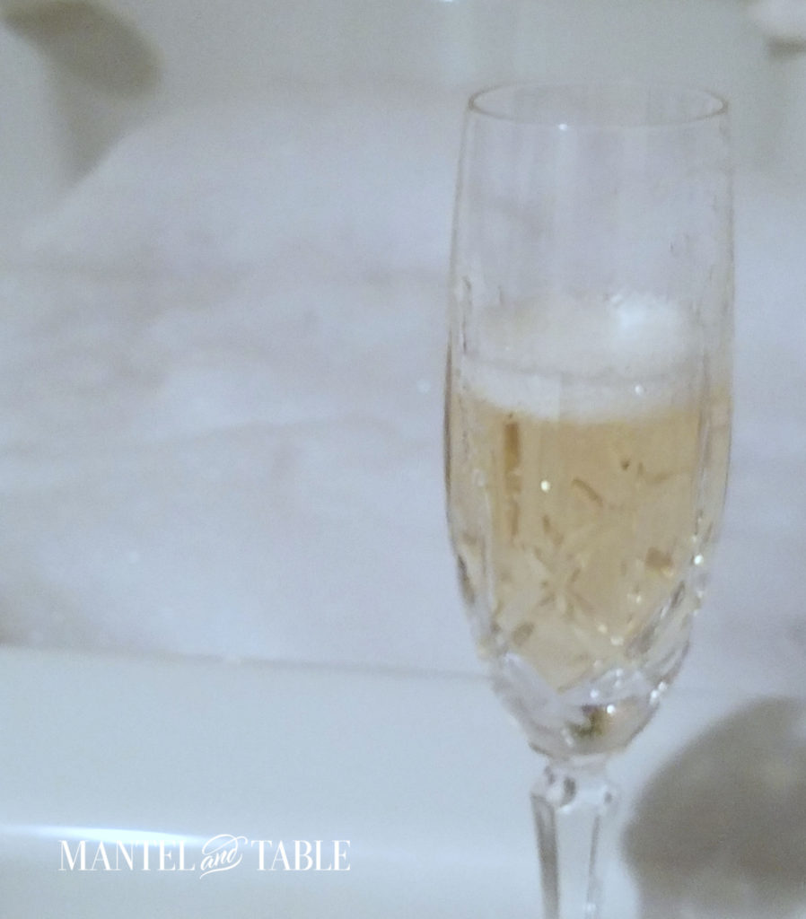 Spa Day ~ Glass of frothy sparkling wine in front of bubble bath