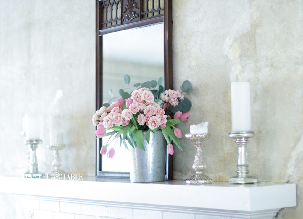 pink flowers in bucket on mantel