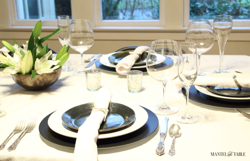 Black & white industrial table setting with centerpiece of white lilies - side view closeup