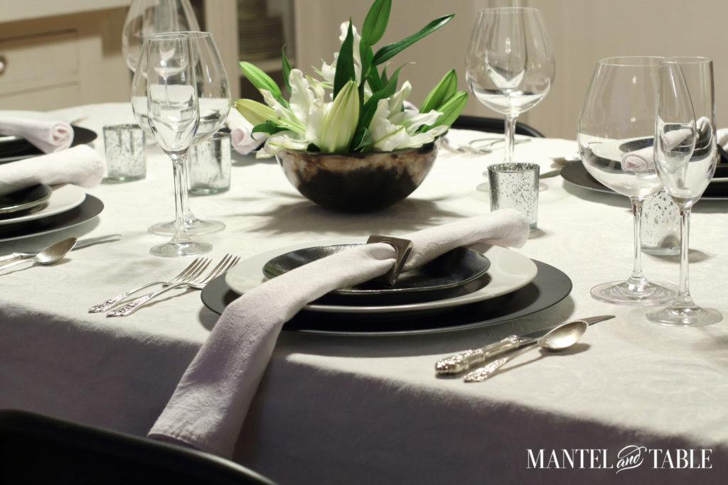Black & white industrial table setting with centerpiece of white lilies - side view