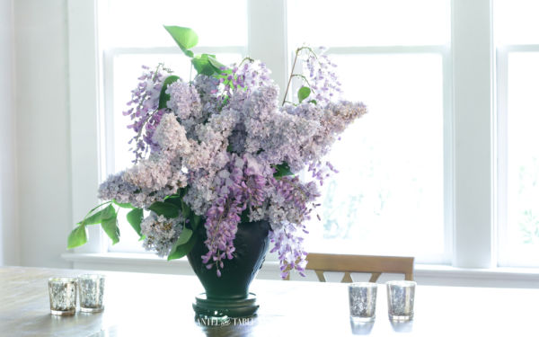 Black amethyst vase of lavender lilacs & wisteria on dining room table