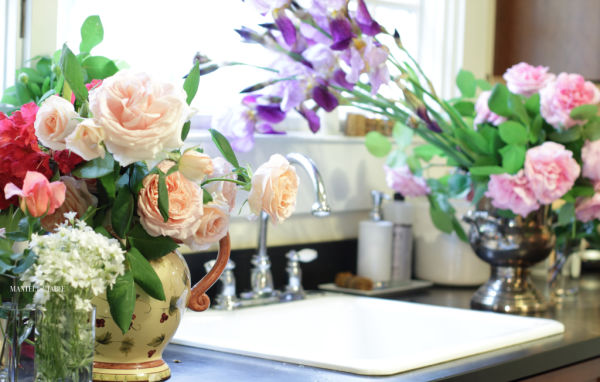 Roses pink, peach, blush, and yellow. Purple iris & red rhodys. Cut fresh flowers from the garden in various vases near the kitchen sink
