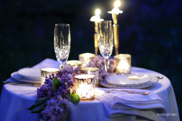 Candlelit table for two with crystal and lilacs