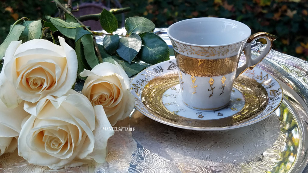 White & Gold demitasse teacup on silver tray with cream colored roses