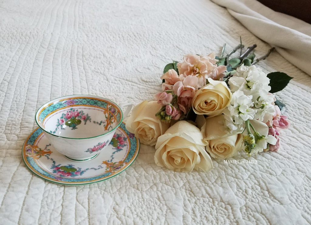 Teal & Pink teacup on cream quilted background with pastel pink & white flowers