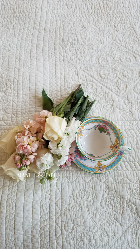 Teal & Pink teacup on cream quilted background with pastel pink & white flowers