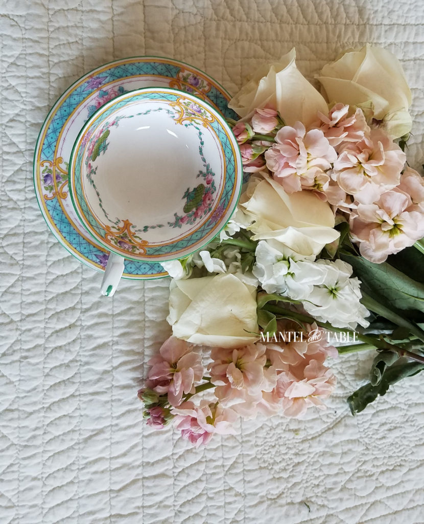 Teal & Pink teacup on cream quilted background with pastel pink & white flowers