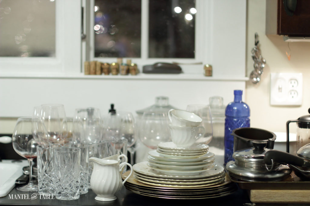Glassware & china organized on the kitchen counter to be washed.