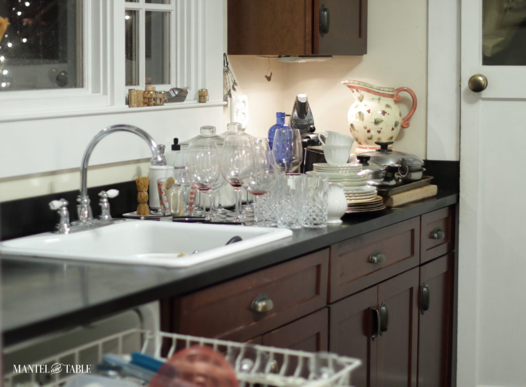 Dishwasher loaded and dishes organized on the counter to be washed.