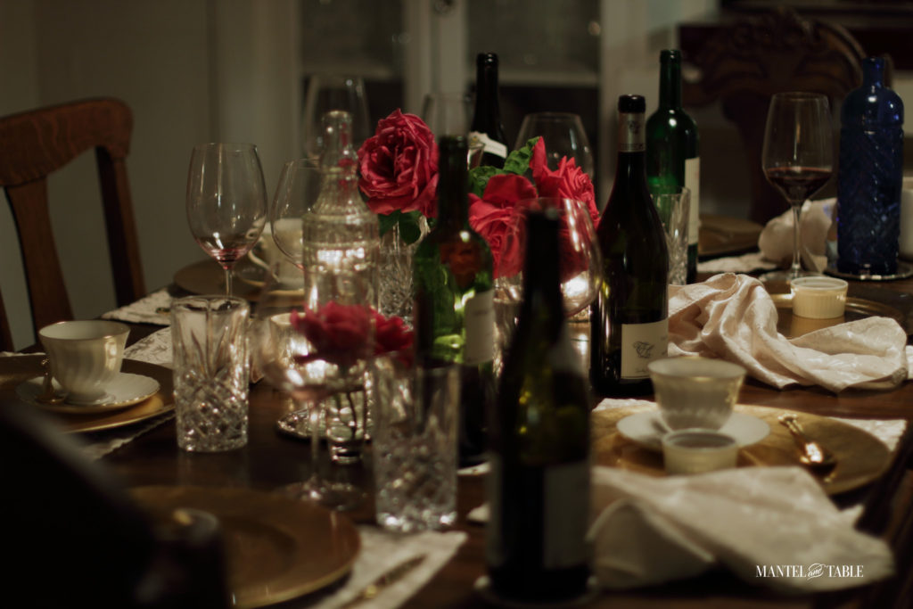 Messy table after a dinner party. Deep pink rose centerpiece.