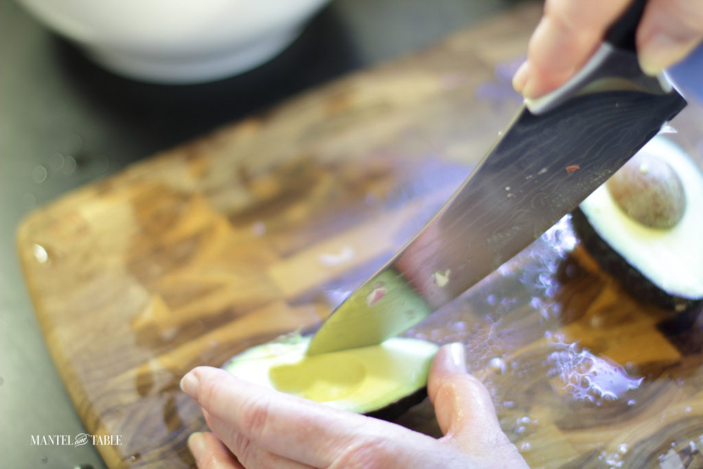 Cutting slices of avocado while it's still in the skin