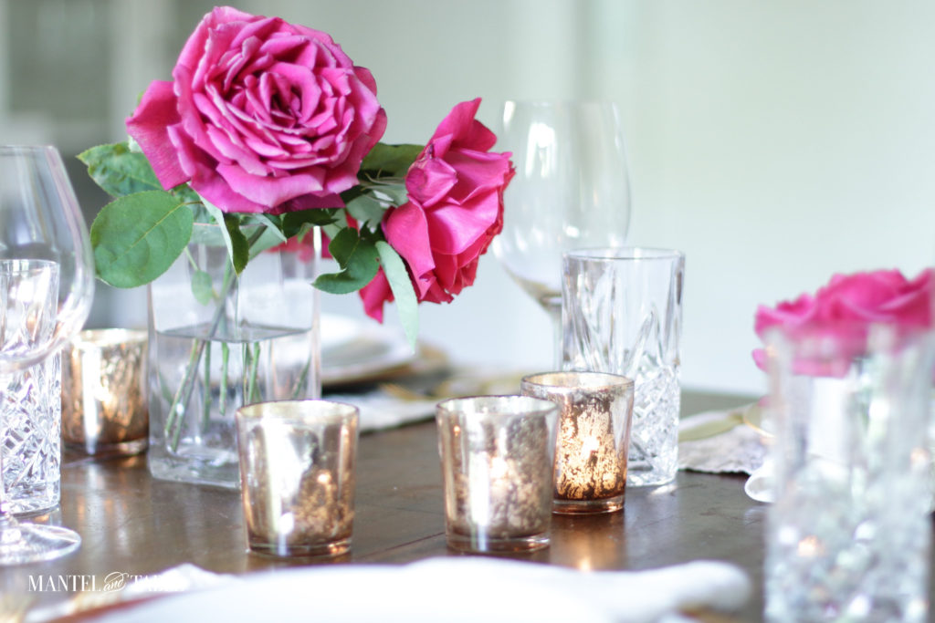 Closeup of pink roses and gold votive candles