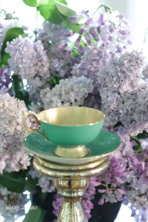 teacup and saucer on top of gold candle holder