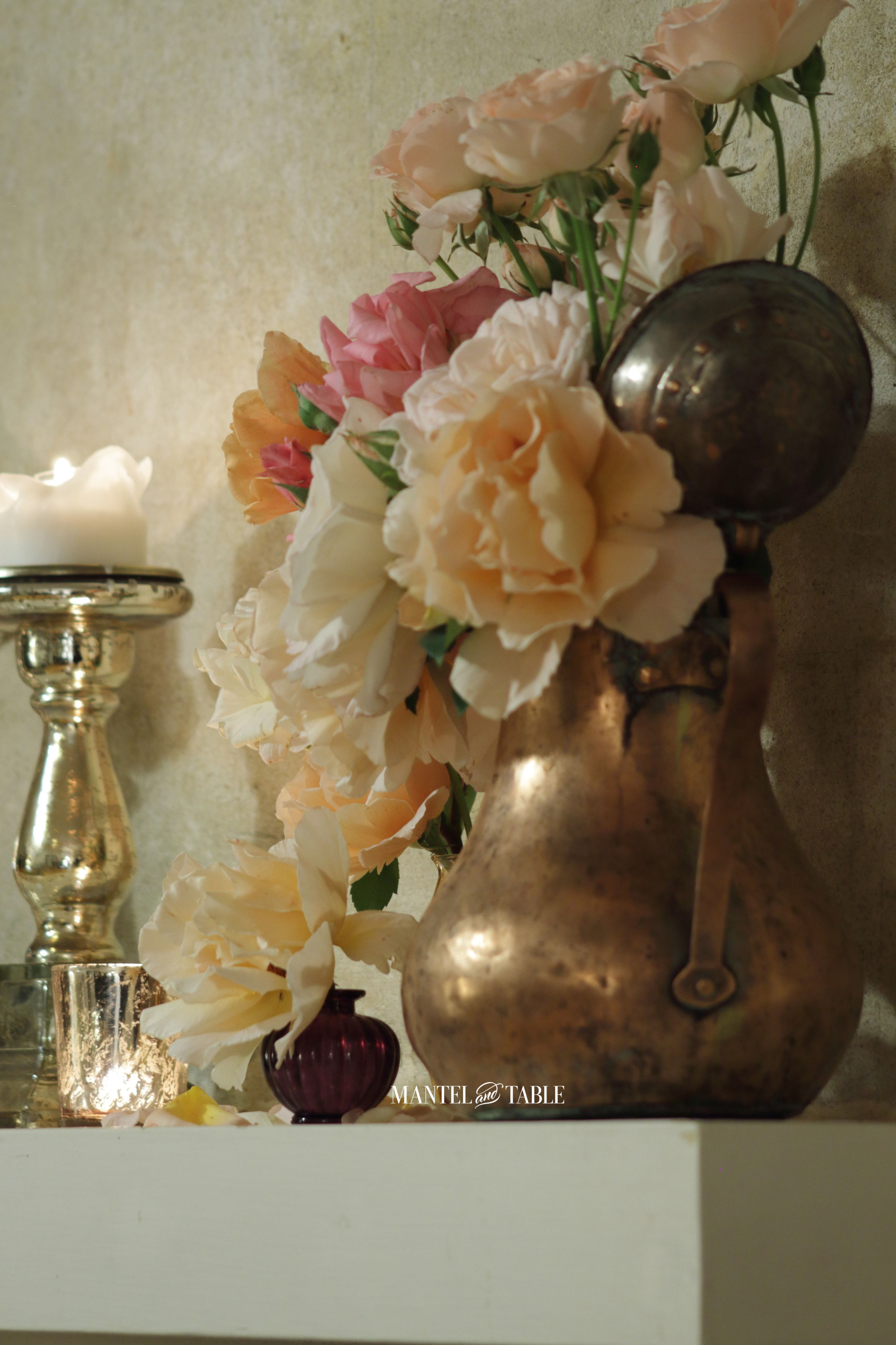 Side view of copper pitcher with roses, and candles