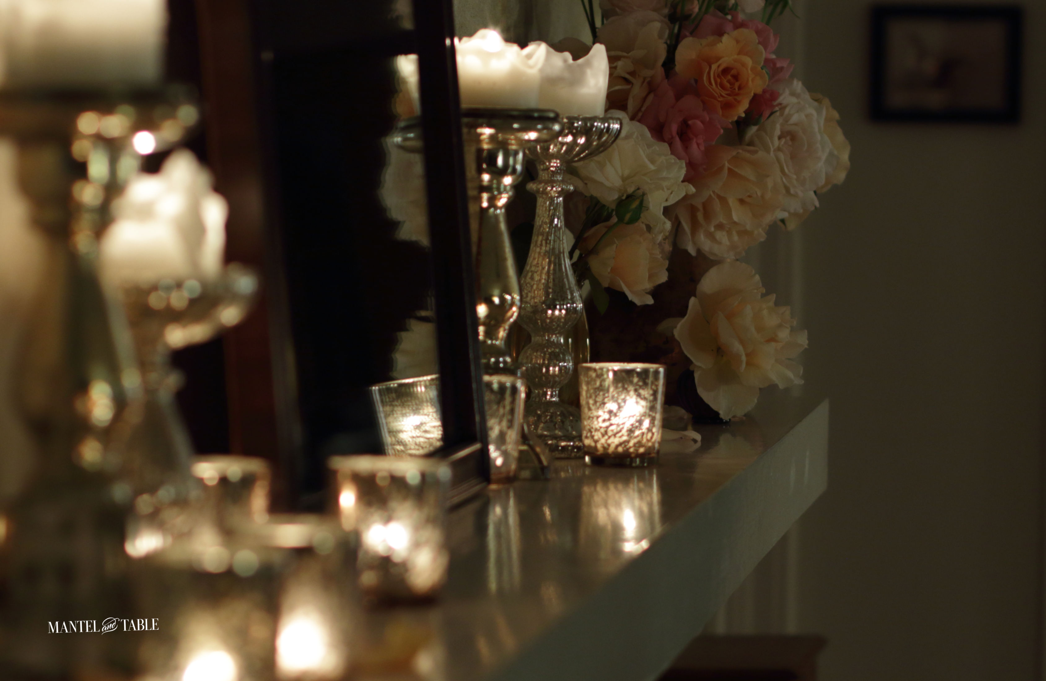 Night shot of garden roses and candles on the mantel