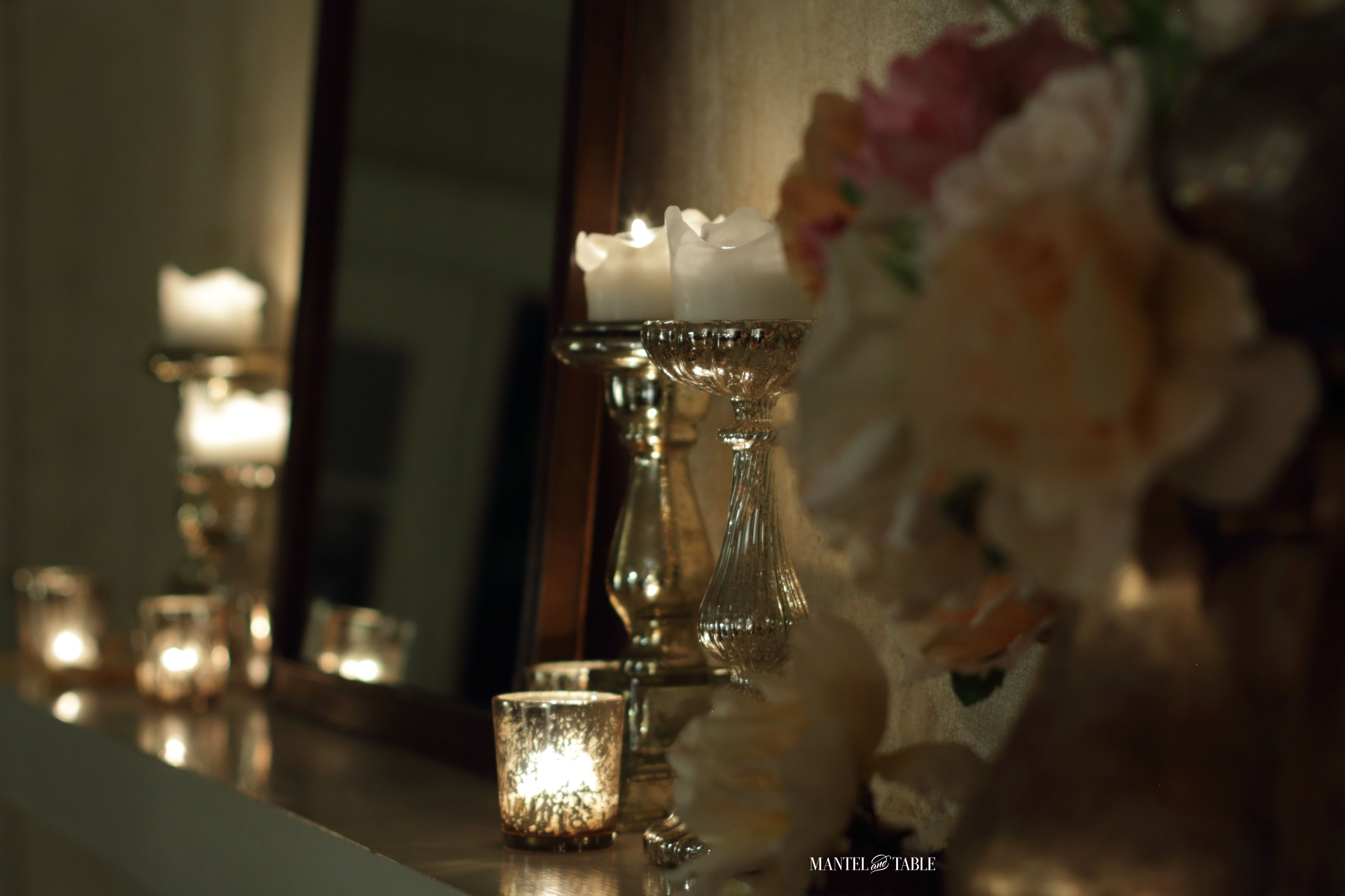 Night shot -close up of roses, candles in the background reflecting in the mirror
