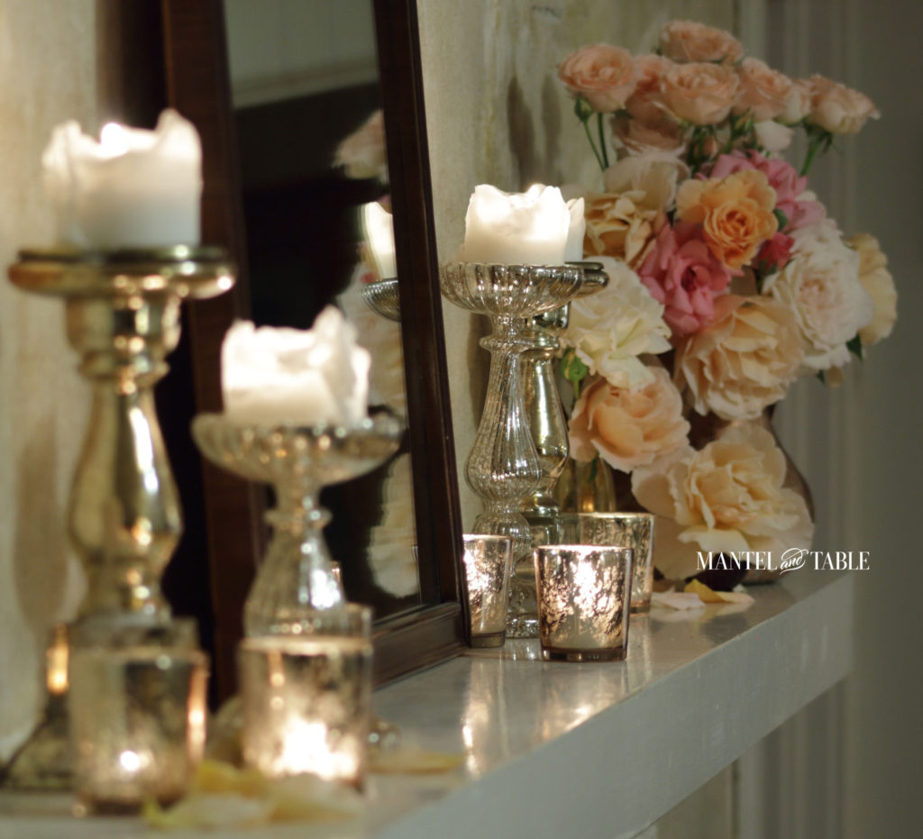Diagonal view of mantel with candles and garden roses