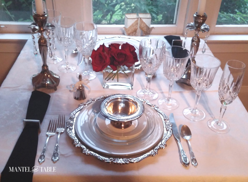 White silver and black table setting with red roses