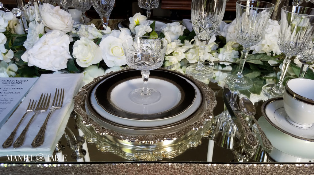 Silver white & black place setting on mirrored table top