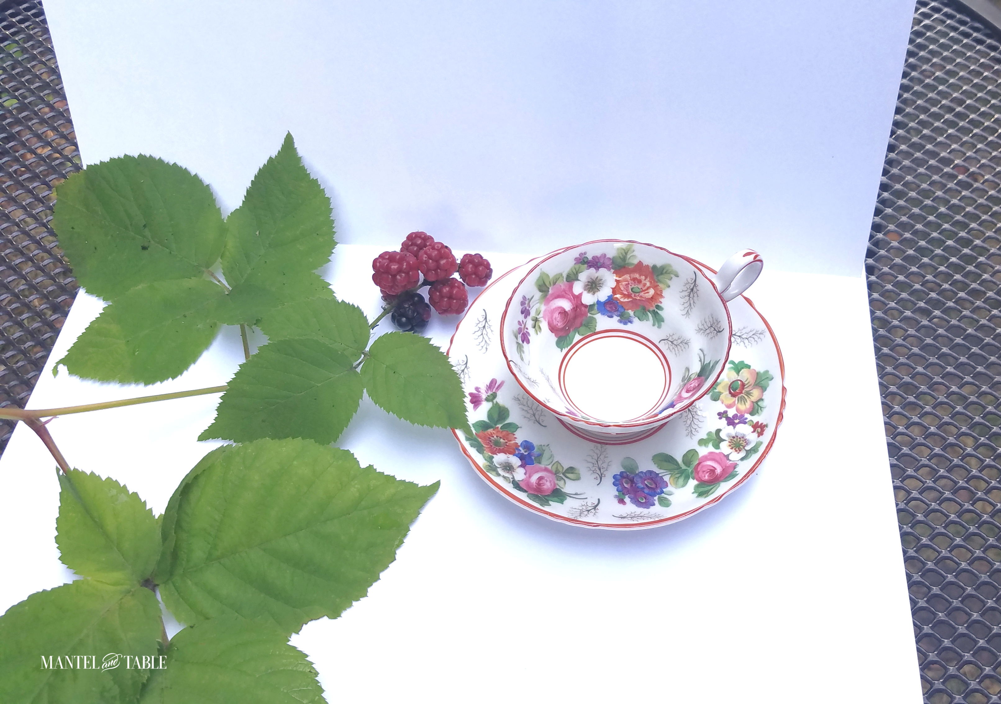 Floral teacup on white paper background on black table