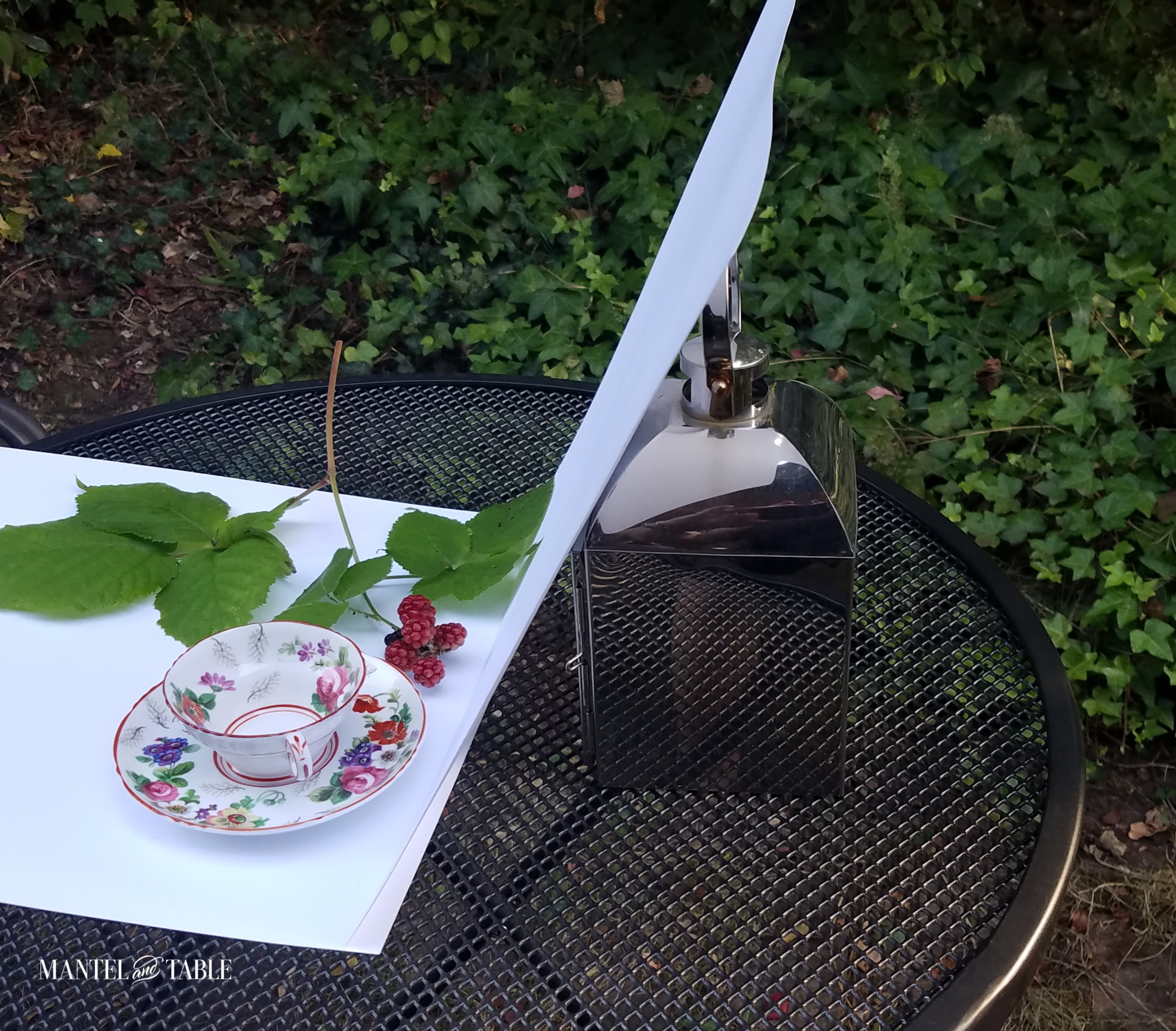one white tagboard pice on table, one leaning against sliver lantern to form background
