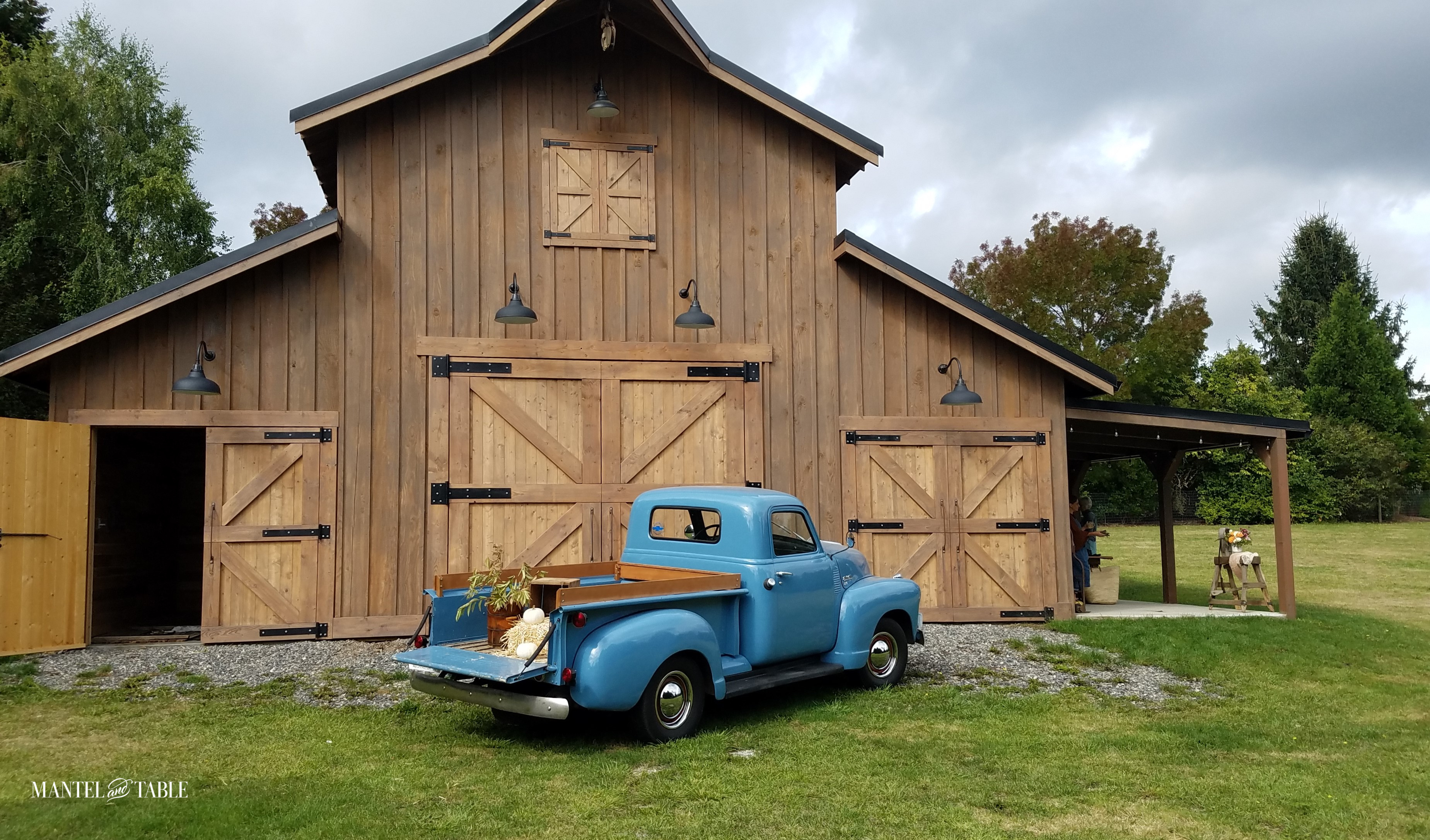 Blue truck in front of brown barn at Made on 23rd.