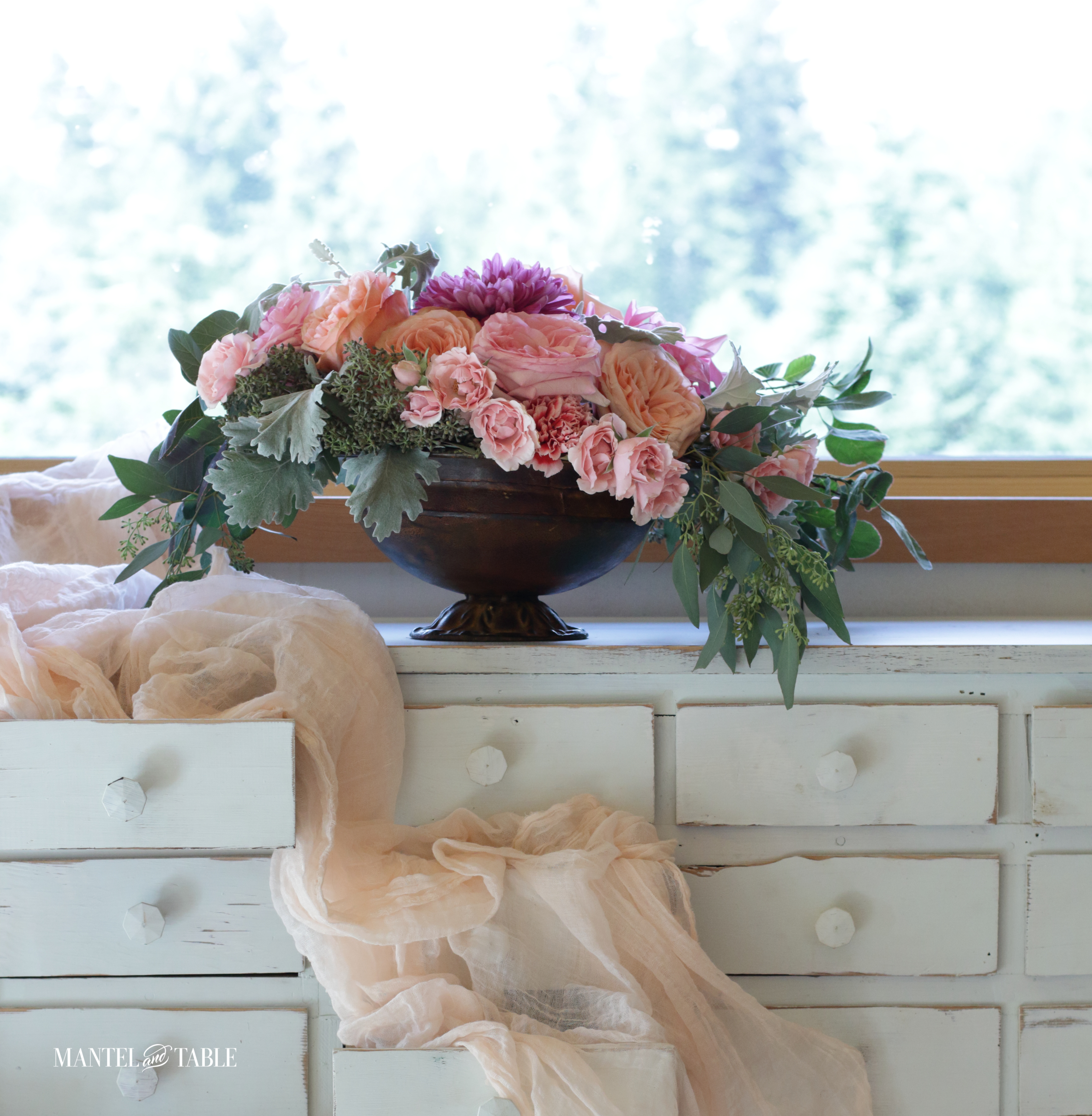 Flower arrangement on a dresser with lots of little drawers
