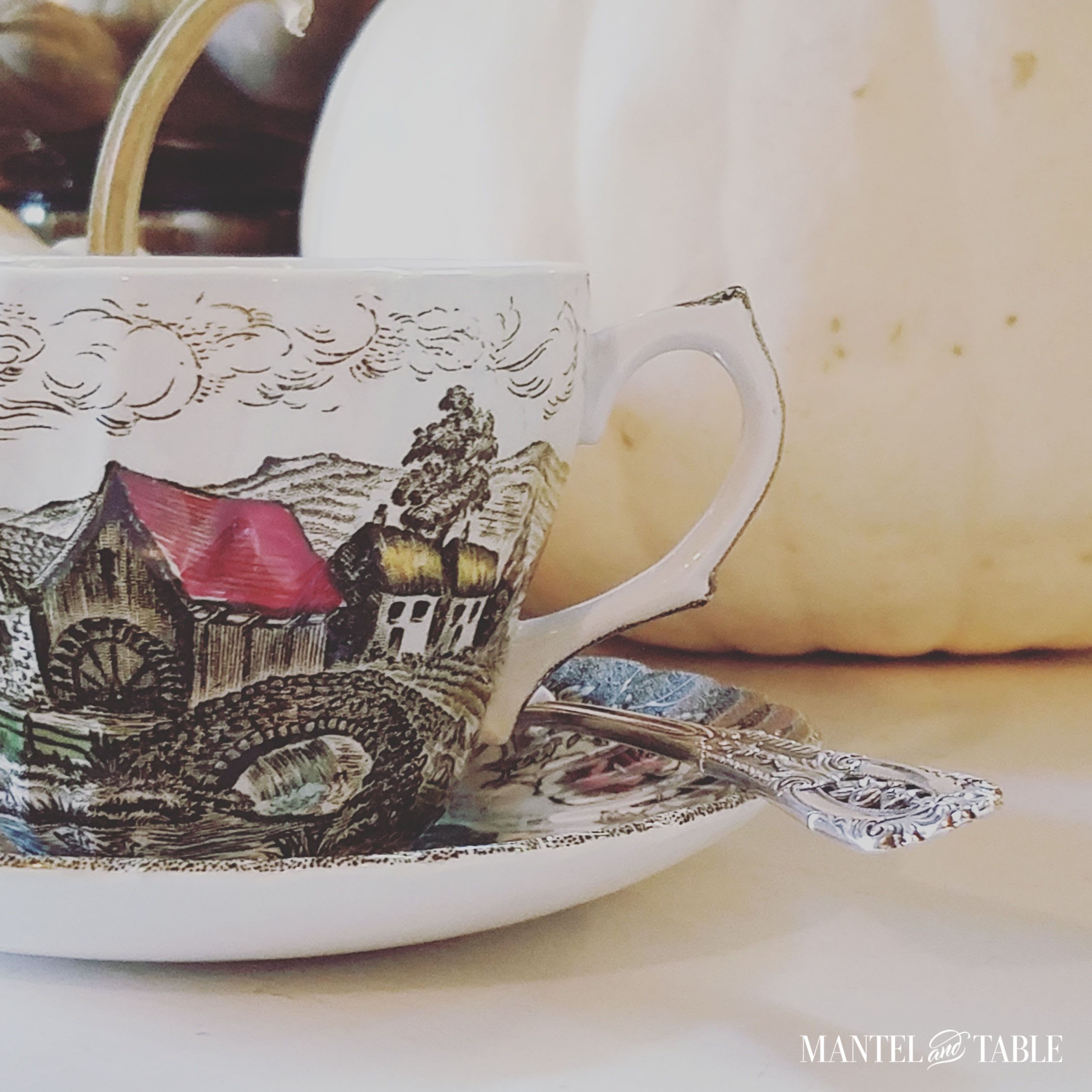 Winter scene teacup next to a white pumpkin