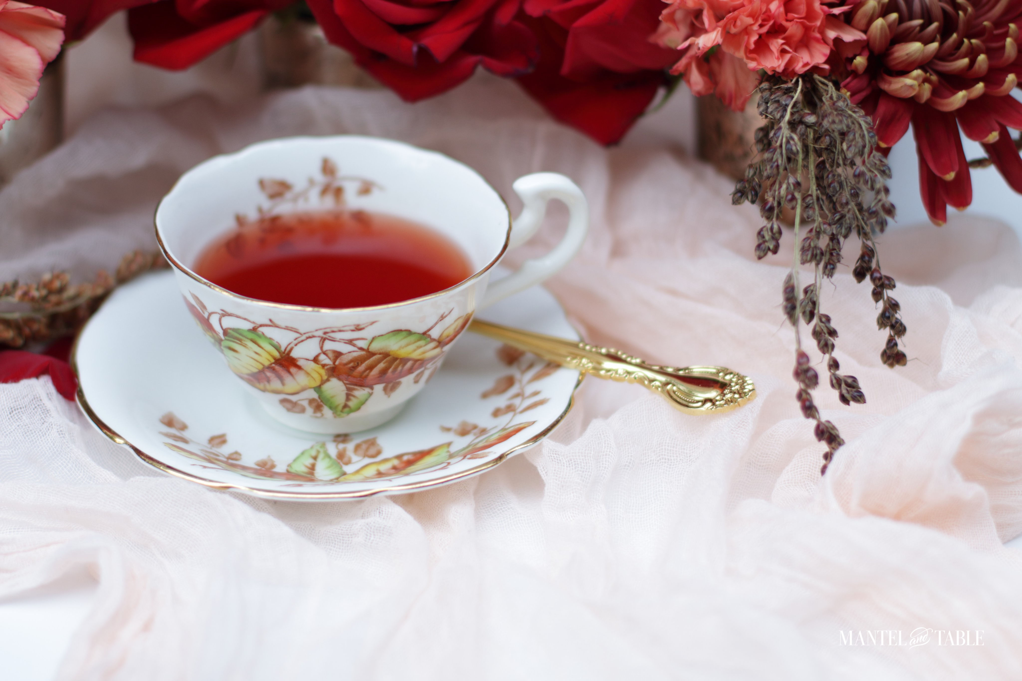 Fall teacup with red tea, gold spoon
