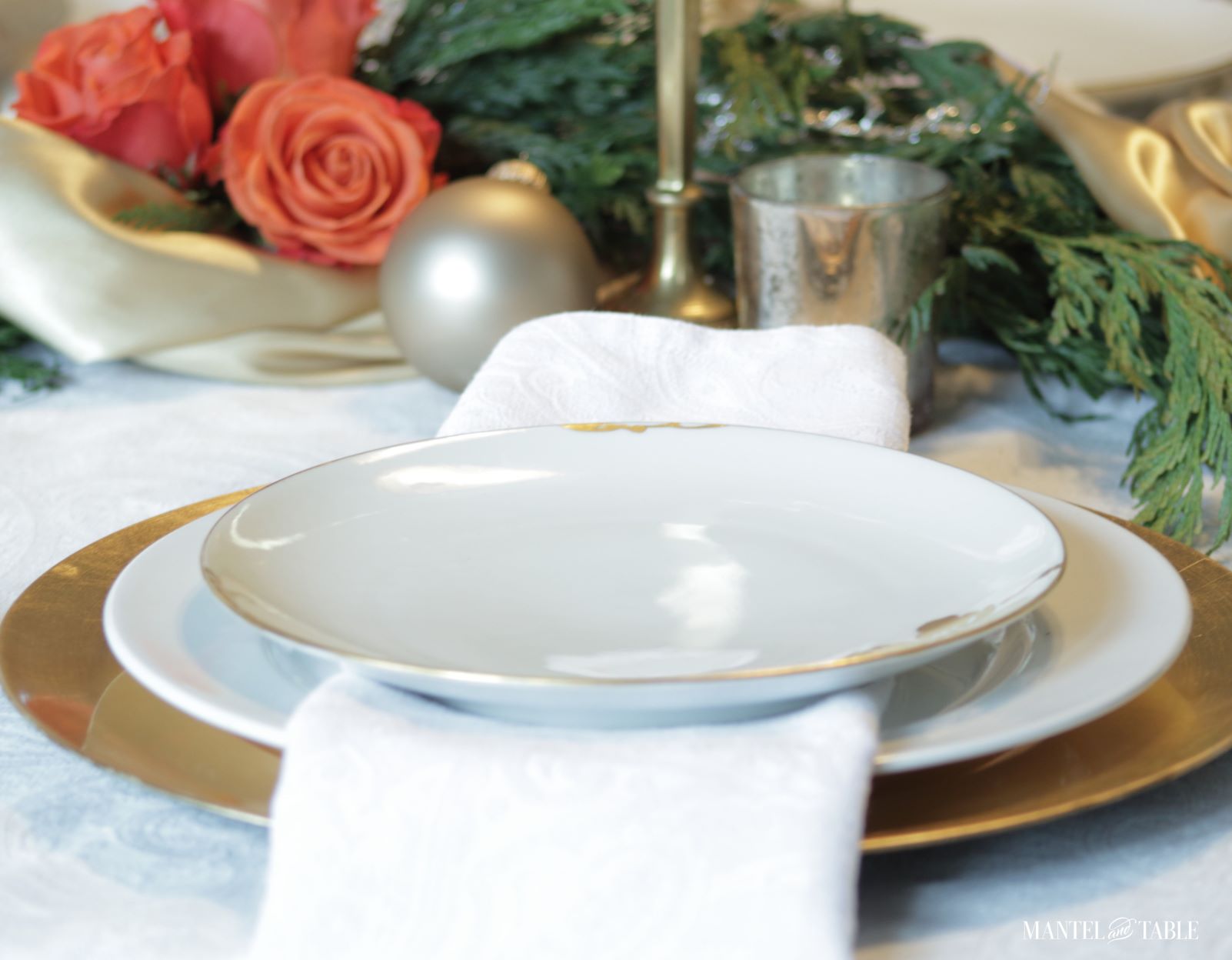 Closeup of plate stack and gold satin centerpiece garland