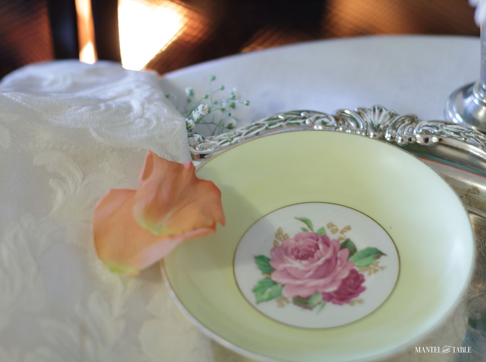 Saucer on silver tray with peach rose petals