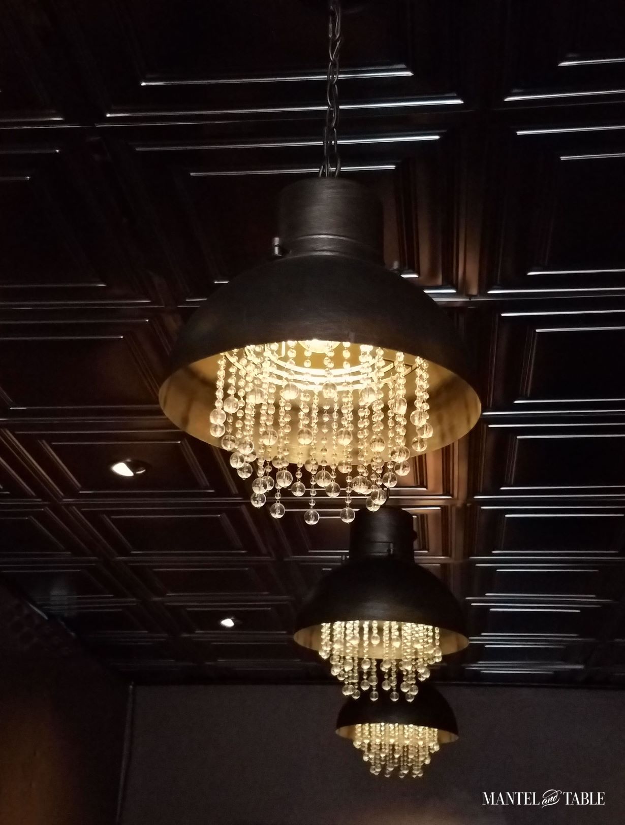 Brute Wine Bar Astoria OR ~ Dark and elegant deco ceiling tiles, dark metal industrial overhead lights with chandelier crystals