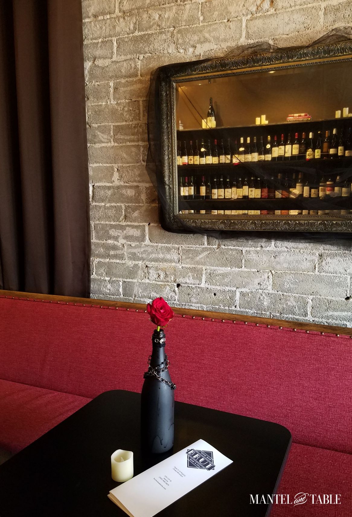 Brute Wine Bar Astoria OR ~ Cozy red banquette, white brick wall, and gilt mirror reflecting shelves of wine