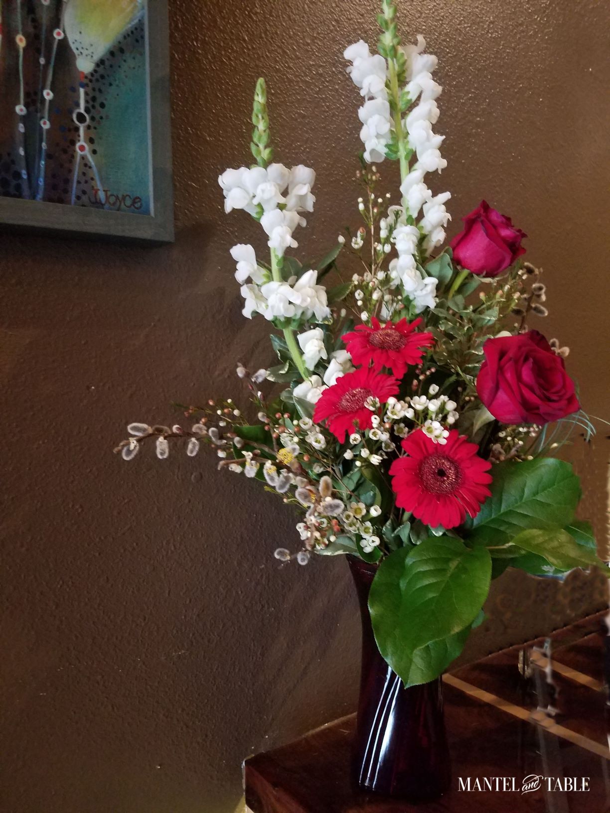 Brute Wine Bar Astoria OR ~ Arrangement of red and white flowers, framed art on the wall