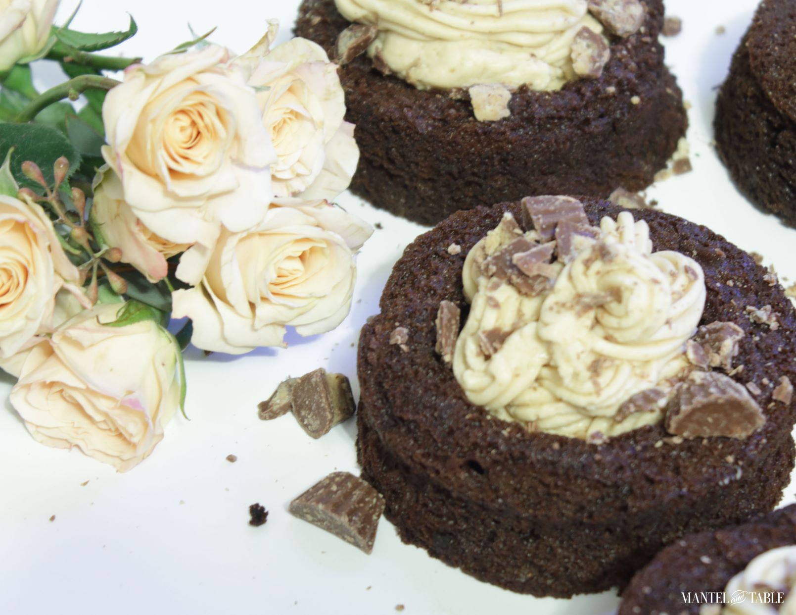 Four tiny chocolate cake cups filled with frosting.
